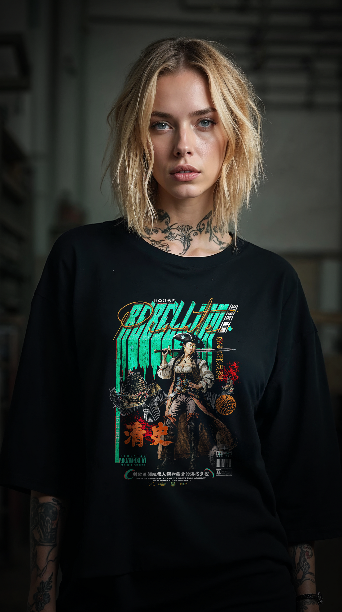 Femme blonde tatouée portant le t-shirt oversize noir REBELLION GREEN, style streetwear rebelle et féministe, coupe ample coton biologique
