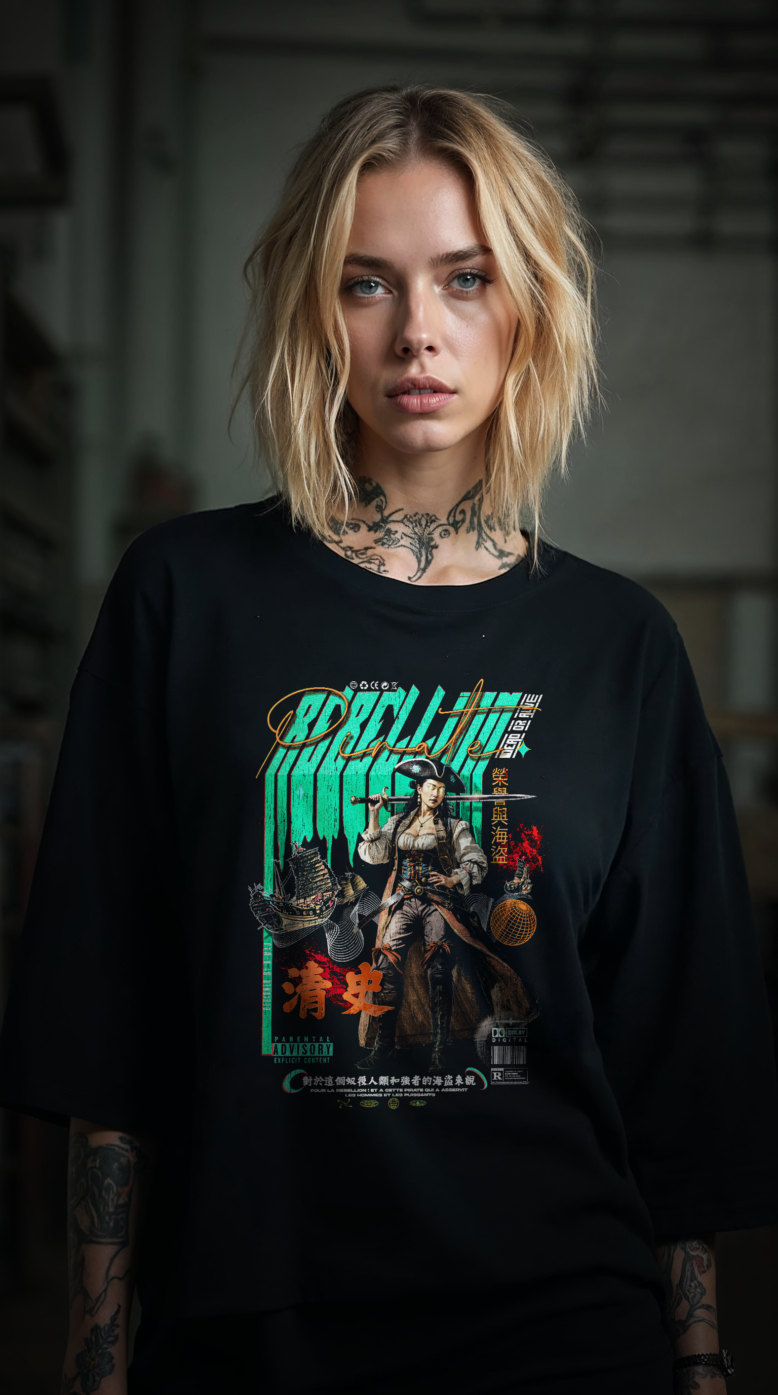 Femme blonde tatouée portant le t-shirt oversize noir REBELLION GREEN, style streetwear rebelle et féministe, coupe ample coton biologique