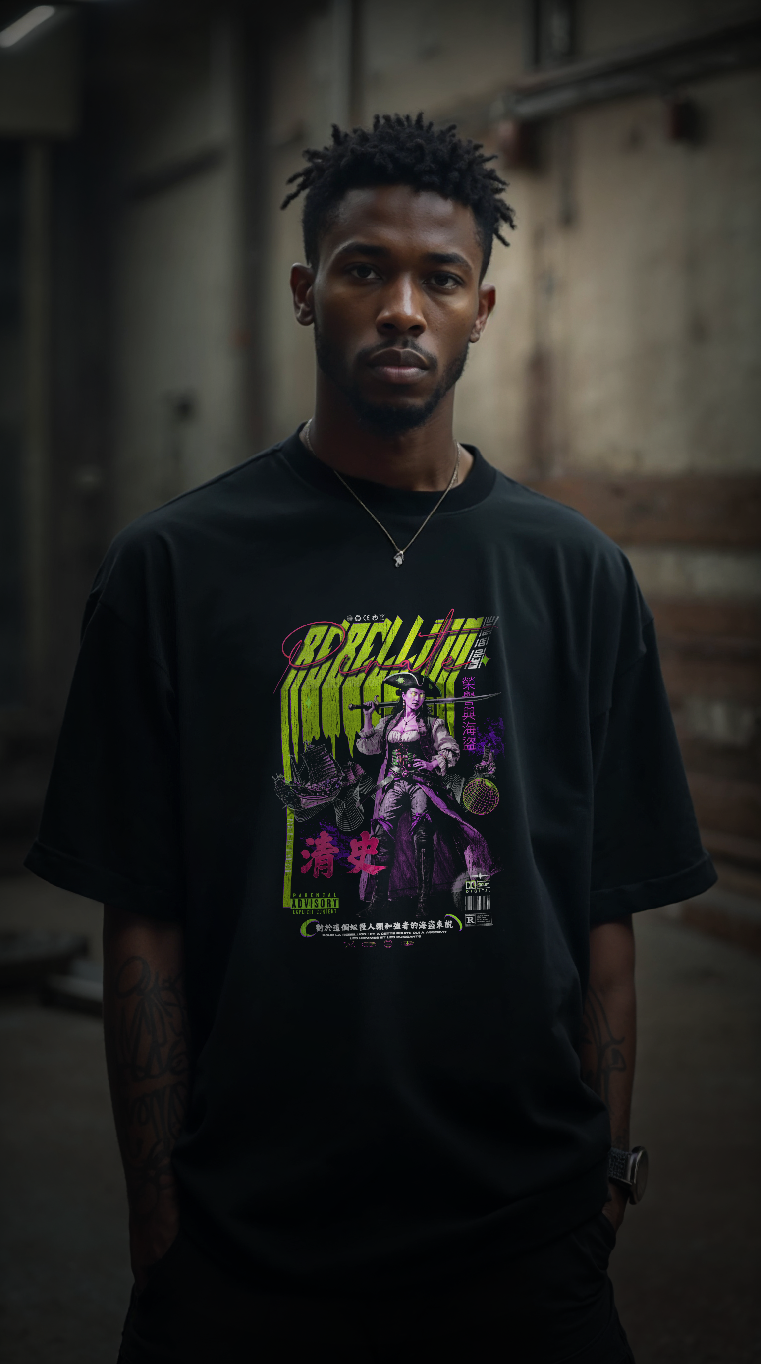 homme portant le t-shirt oversize noir REBELLION yellow flash FLUO, coupe ample streetwear, design graphique rebelle, fond parking urbain industriel