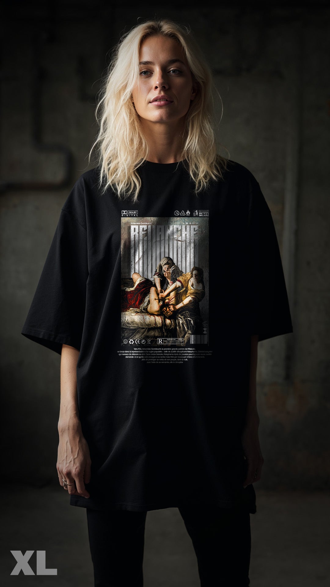 T-shirt noir XL REVANCHE inspiré du tableau d’Artemisia Gentileschi vu de face avec graphic imprimé sur le devant, porté par femme ambiance cinématographique, style streetwear vintage, fond street bokeh