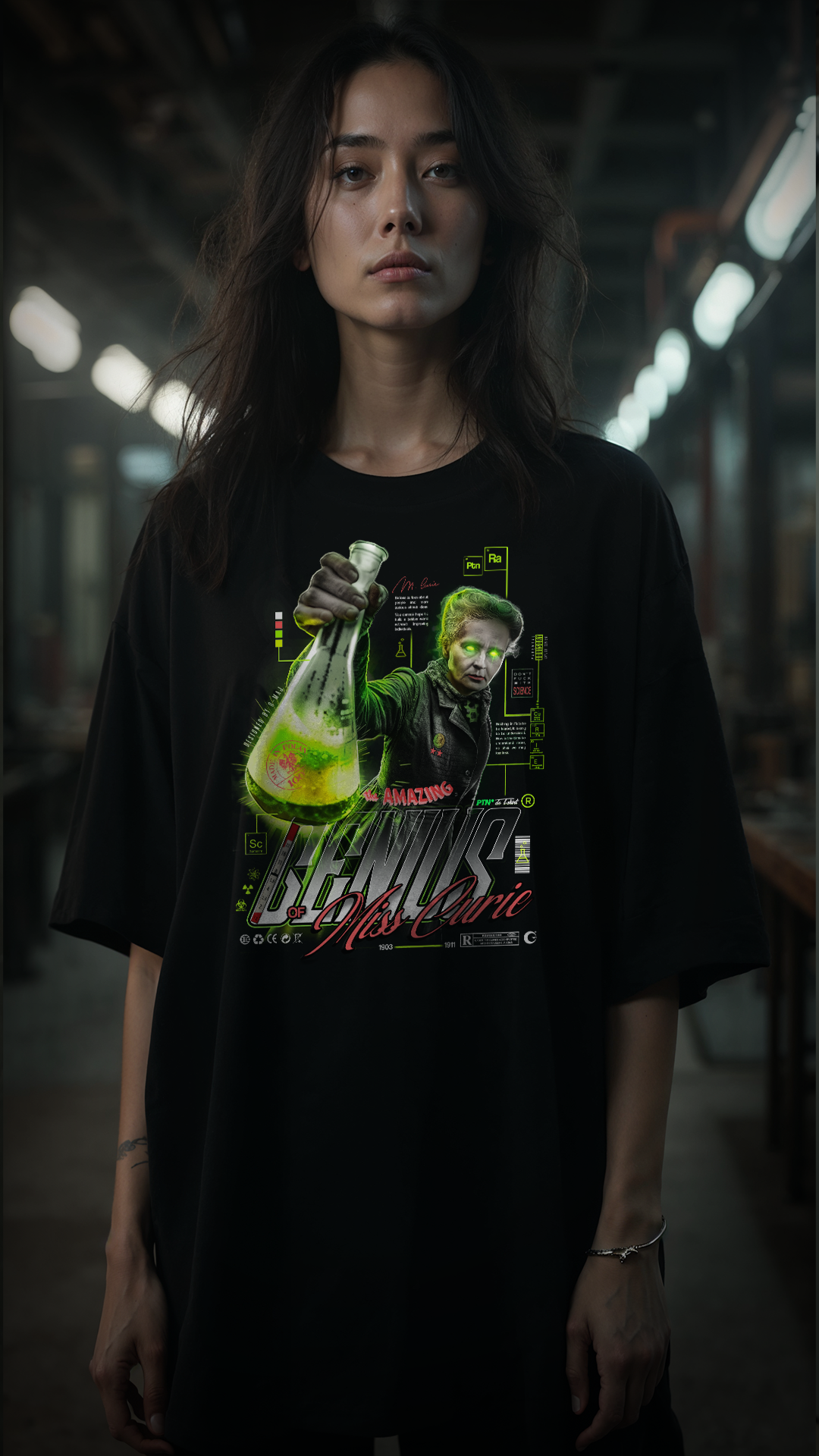Femme aux cheveux longs portant le t-shirt noir oversize GENIUS PTN* DE T-SHIRT, graphic vintage Marie Curie au flacon vert lumineux, style streetwear dans un environnement industriel