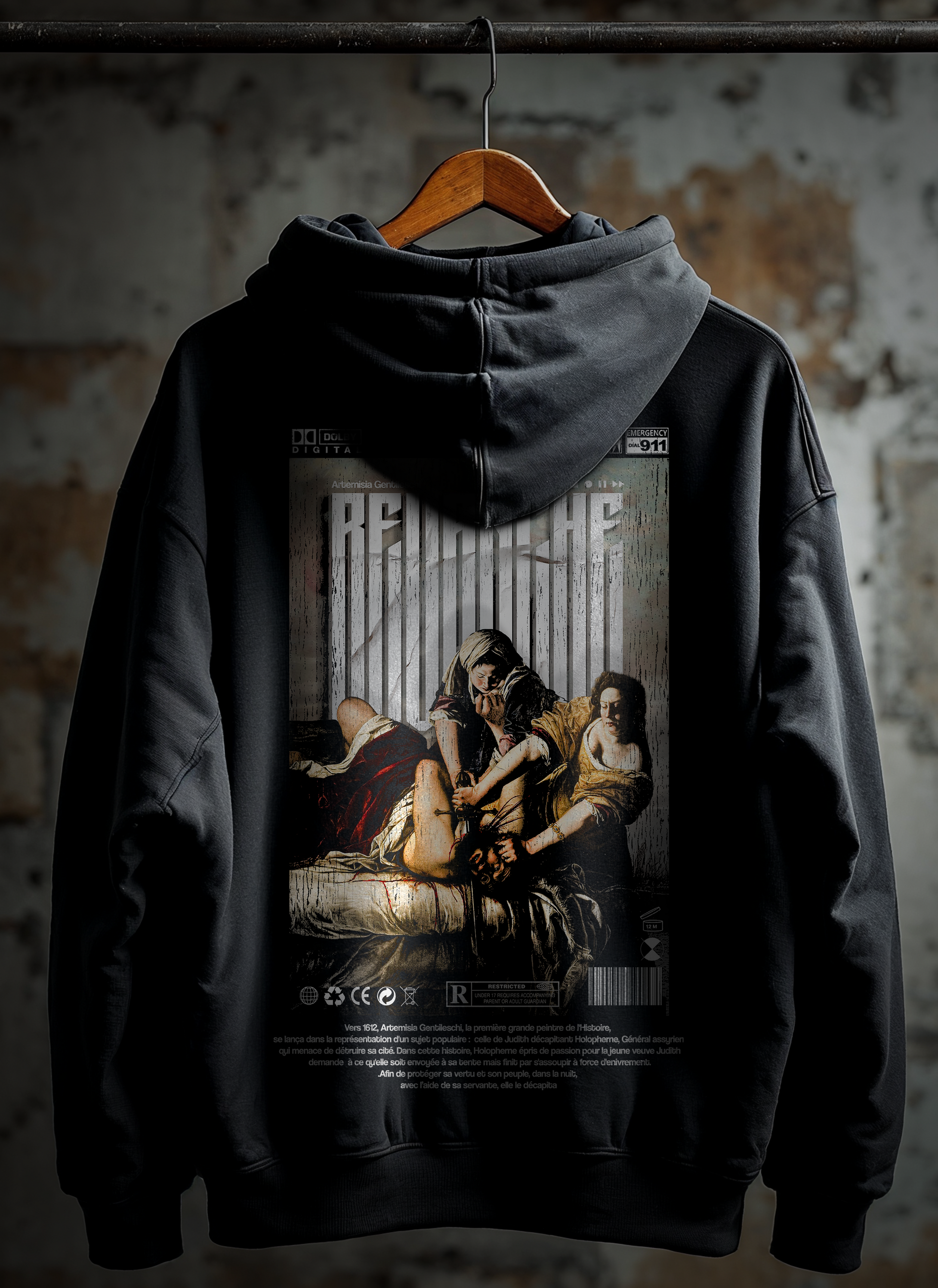Vue dos du Hoodie Revenge Epic sur cintre : graphic arrière REVANCHE d’Artémisia style illustration baroque, hoodie noir effet délavé vintage streetwear, fond mur rouillé