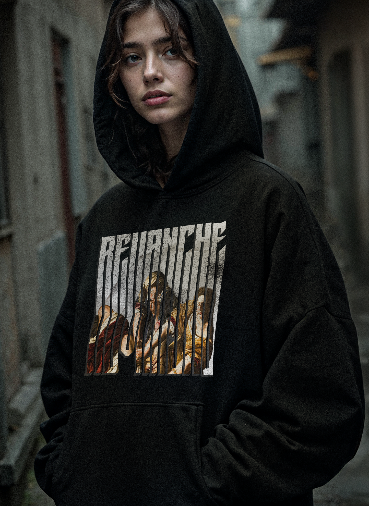 Hoodie Revenge Epic sur modèle femme : graphic REVANCHE frontal d’Artemisia style illustration baroque, renaissance, hoodie noir effet délavé vintage streetwear, fond rue floue